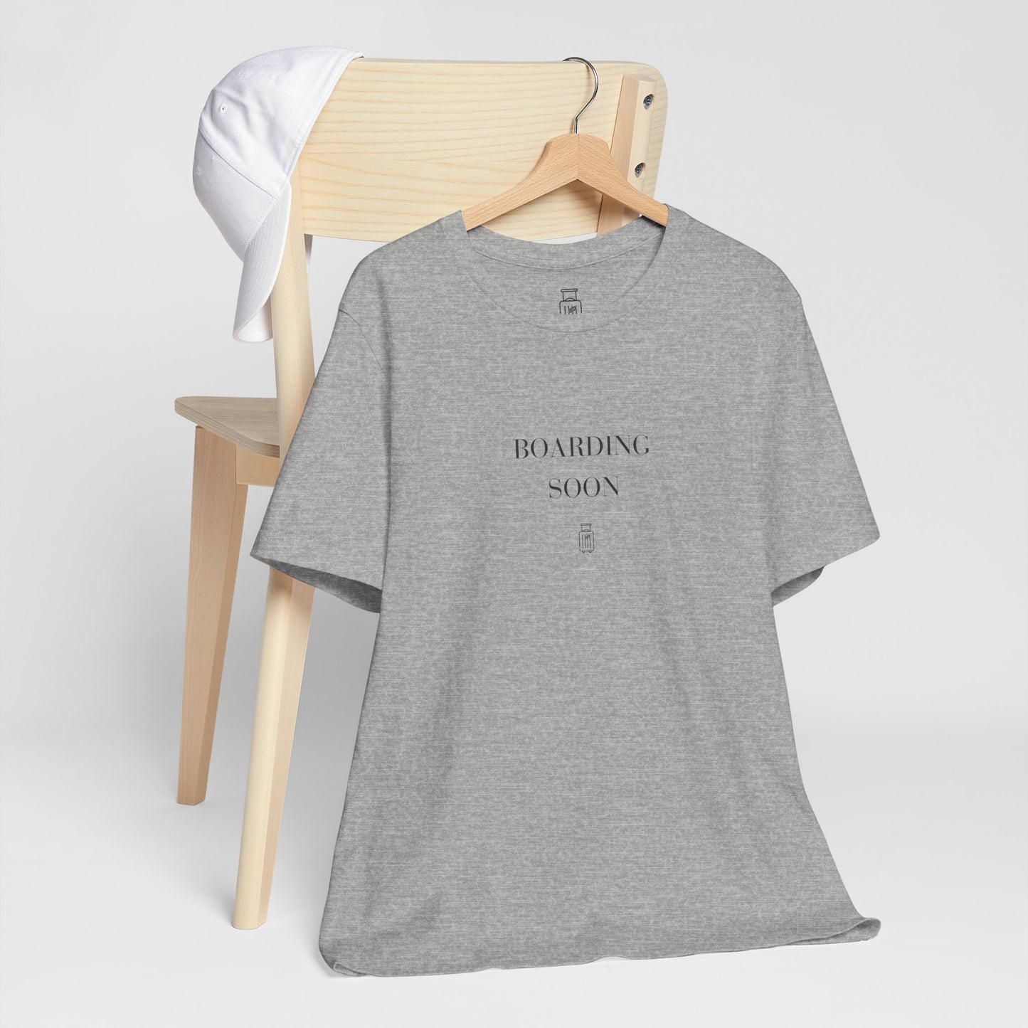 Boarding Soon travel tee displayed on a hanger in a neutral studio setting
