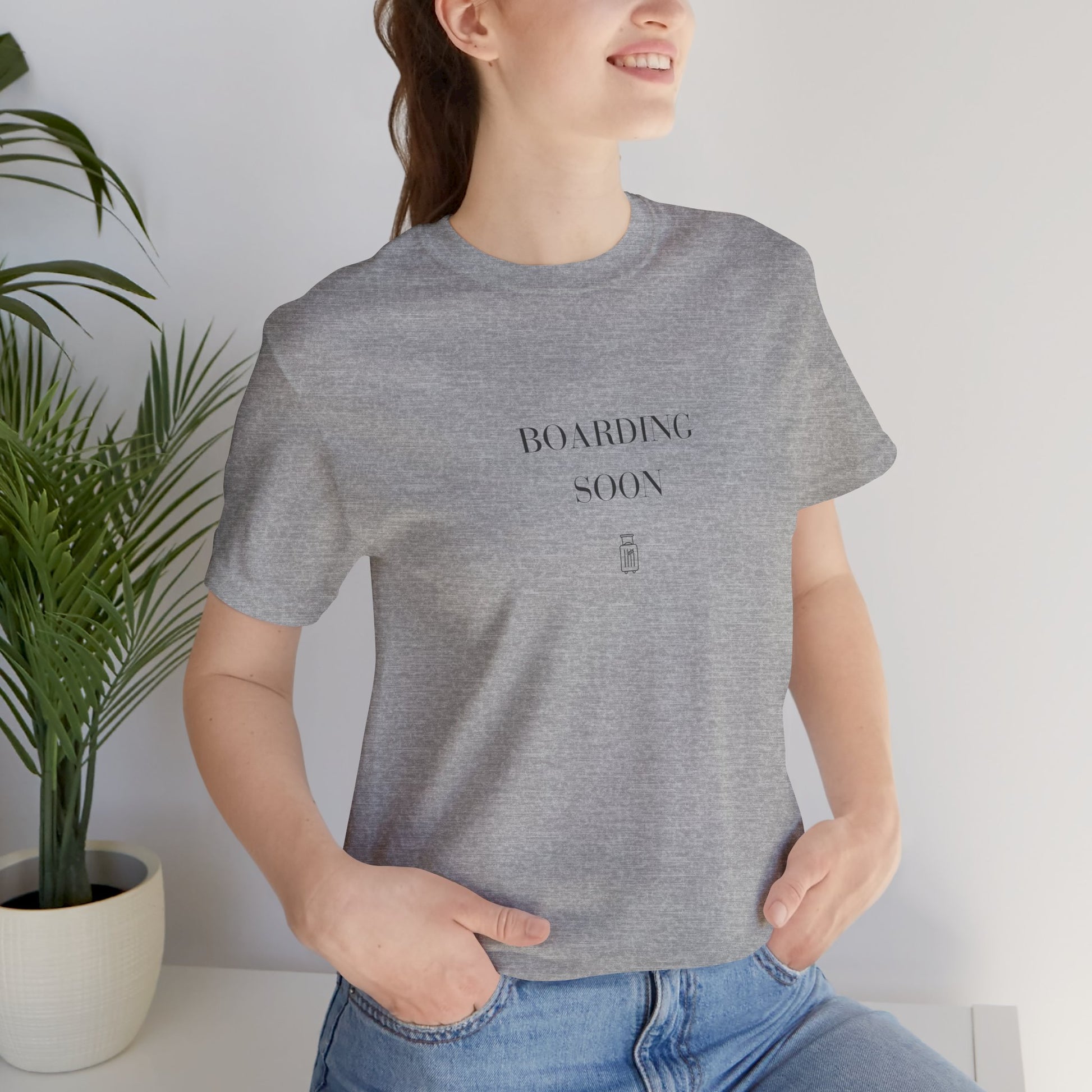 Woman wearing the Boarding Soon Bella+Canvas 3001 tee in Athletic Heather