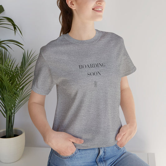 Woman wearing the Boarding Soon Bella+Canvas 3001 tee in Athletic Heather
