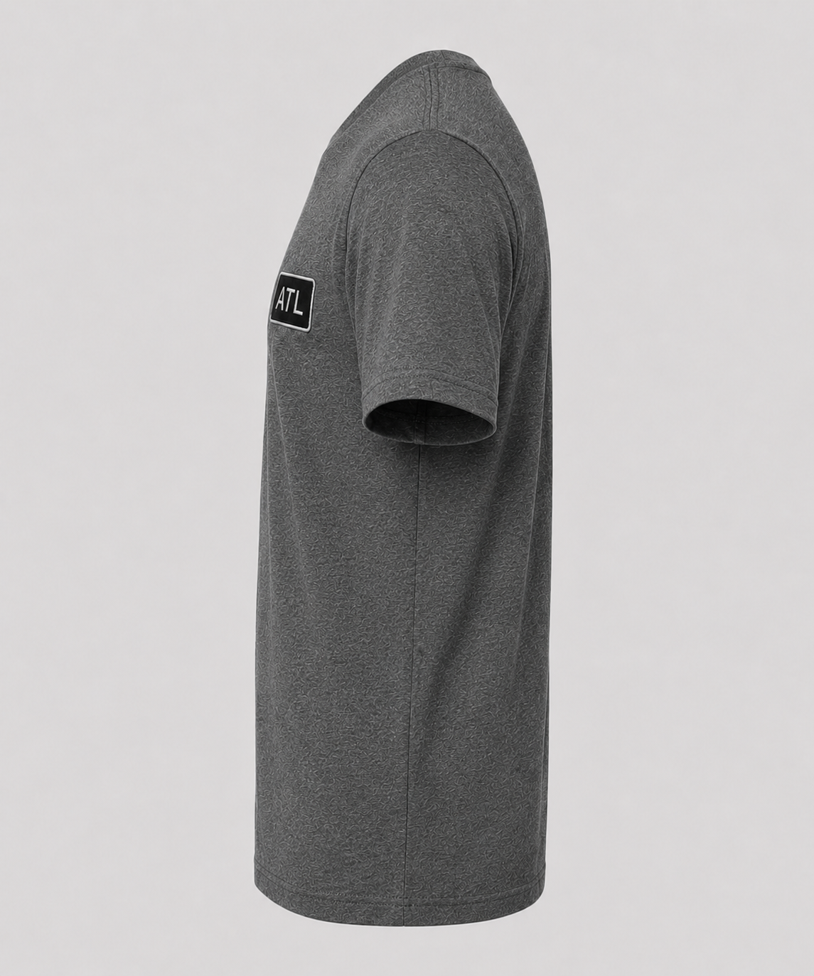 Gray t-shirt with a patch on the sleeve against a light gray background