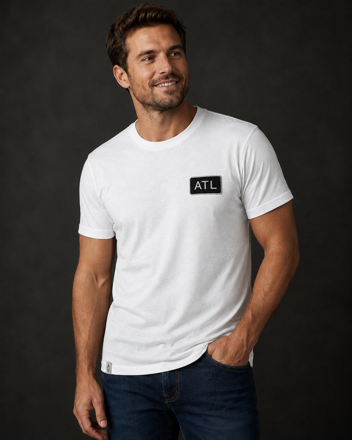 Man wearing a white t-shirt with 'ATL' logo against a dark background