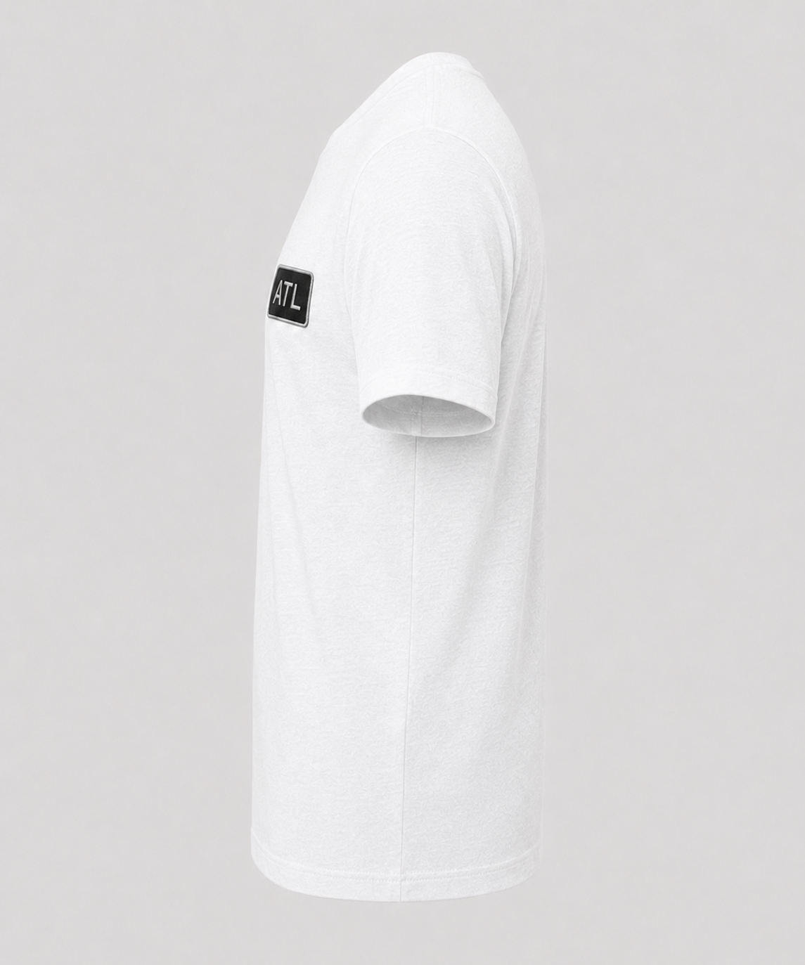White t-shirt with a small black logo on the chest against a light gray background