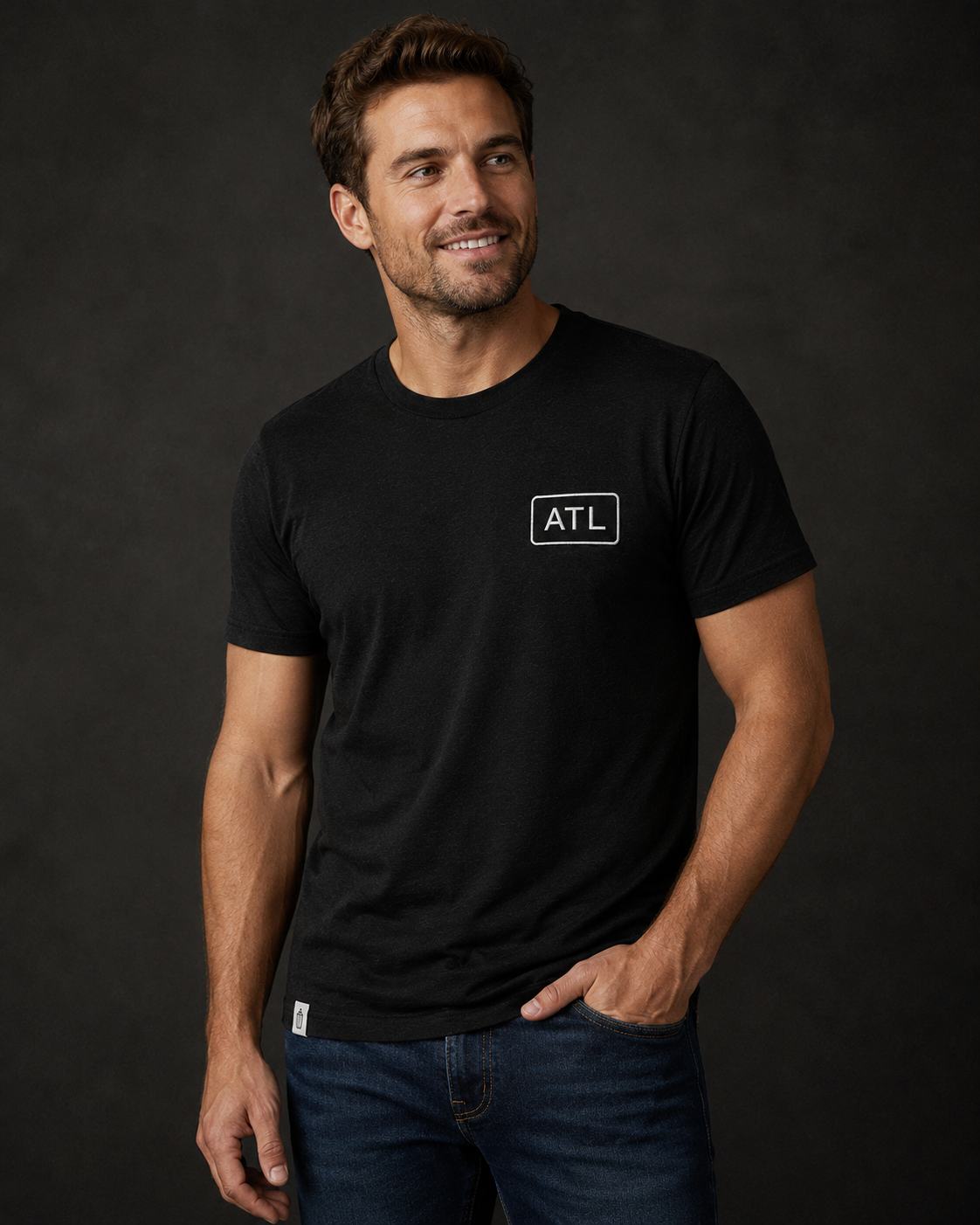 Man wearing a black t-shirt with 'ATL' logo against a dark background