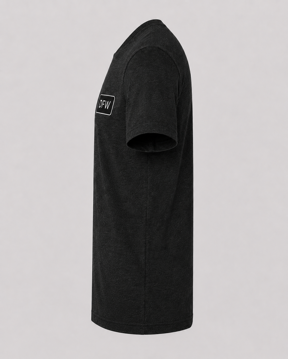 Black t-shirt with a logo on the sleeve against a gray background