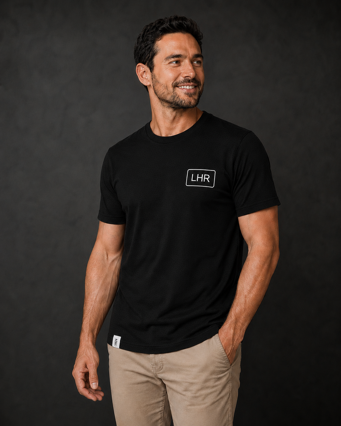 Man wearing a black t-shirt with 'LHR' logo against a dark background