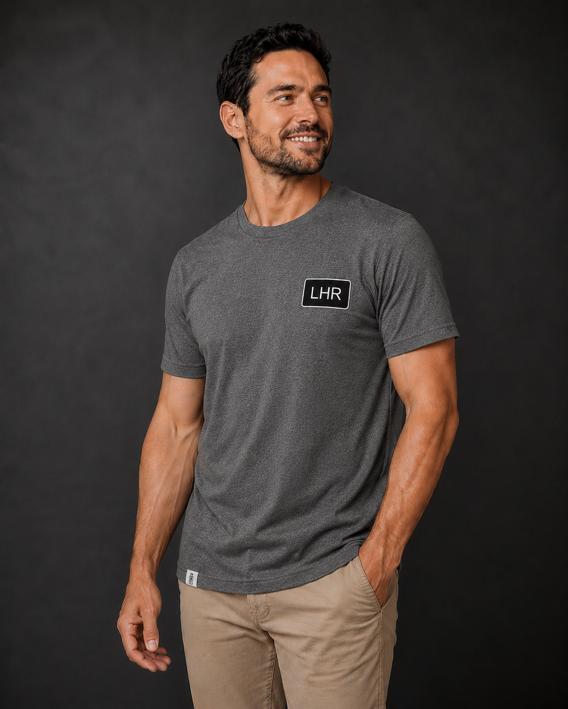 Man wearing a gray t-shirt with 'LHR' logo against a black background