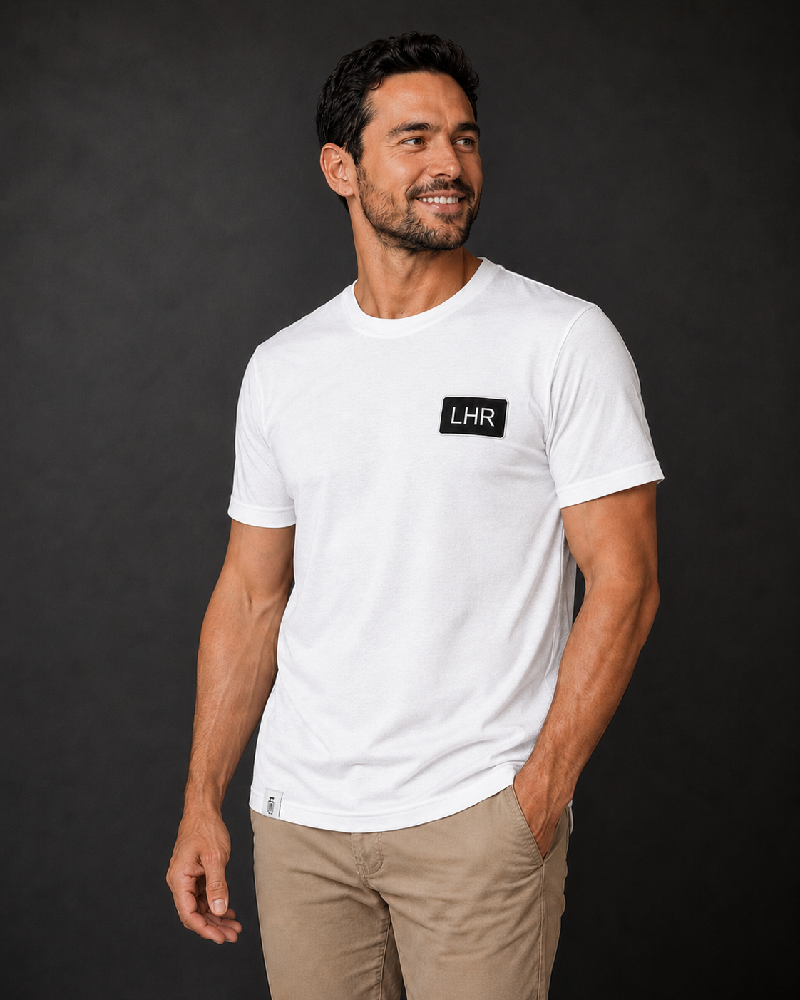 Man wearing a white t-shirt with 'LHR' logo against a black background