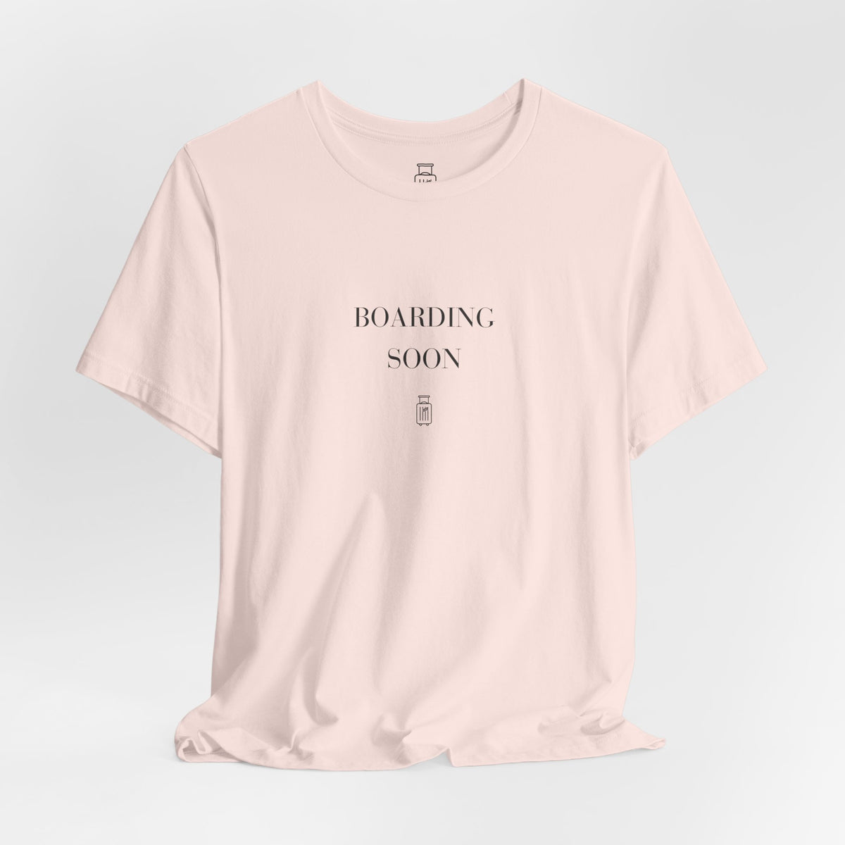 Boarding Soon travel T-shirt in Soft Pink, hanging view